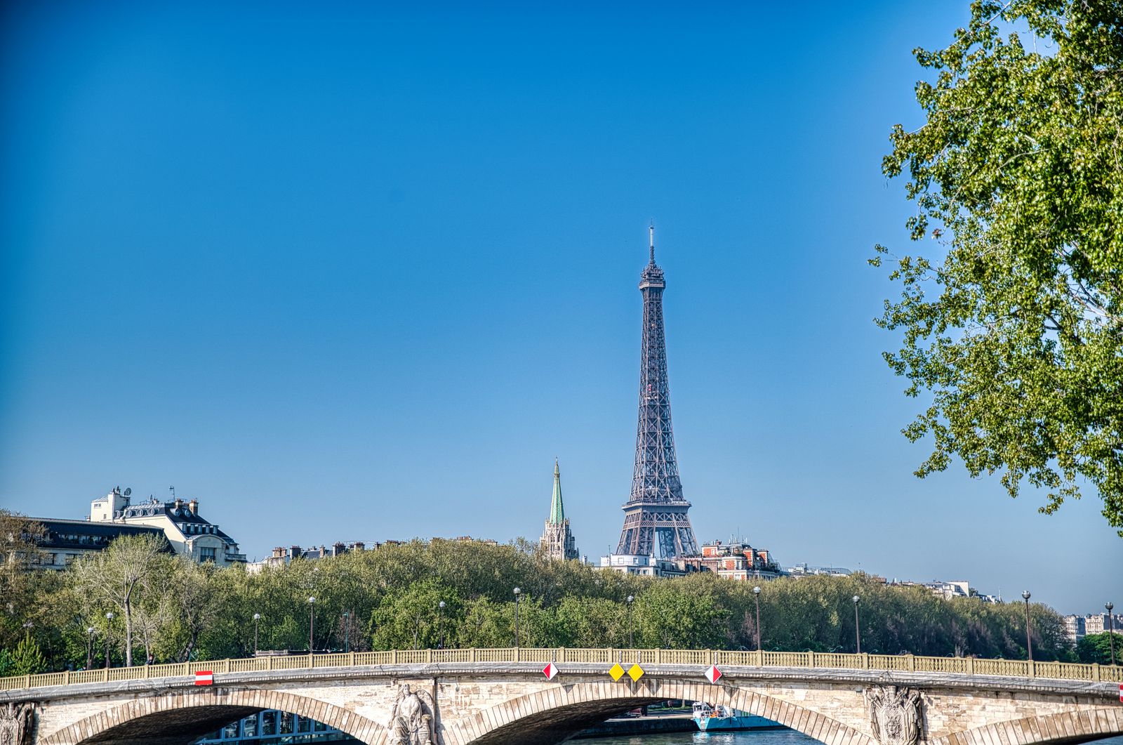 La tour Eiffel à Paris, vue depuis la Seine sous un ciel bleu